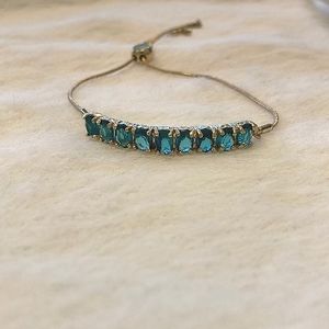 Woman’s adjustable gold chain bracelet with blue gemstones. New aquamarine